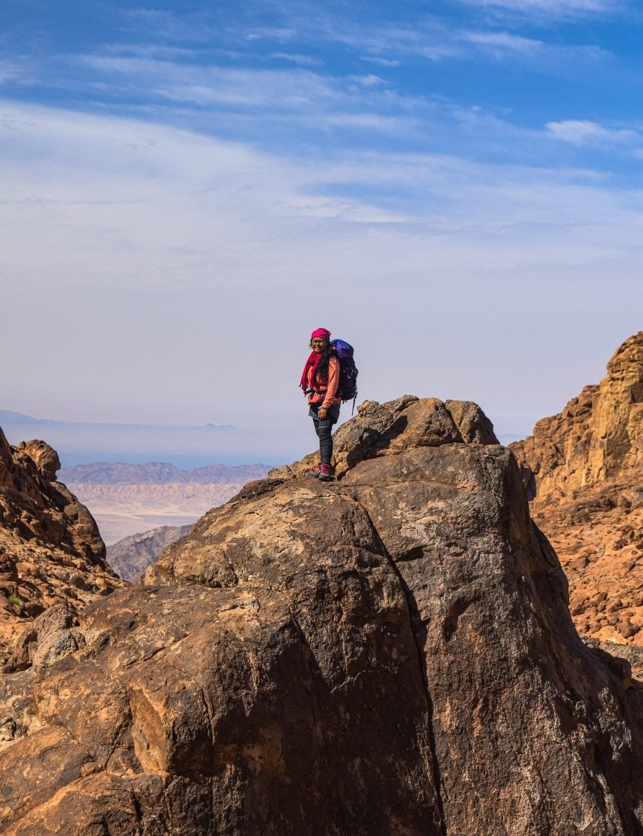 A woman standing on a rocky overlook