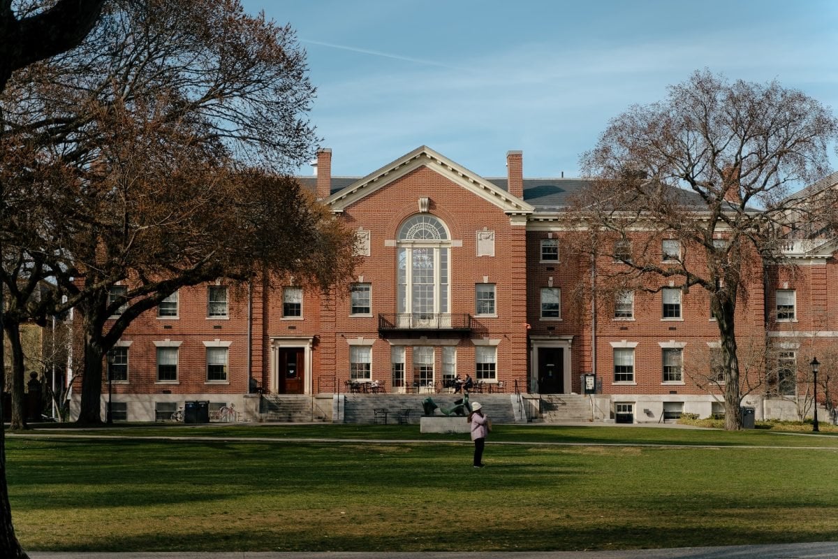 A brick building with a grassy quad in front of it