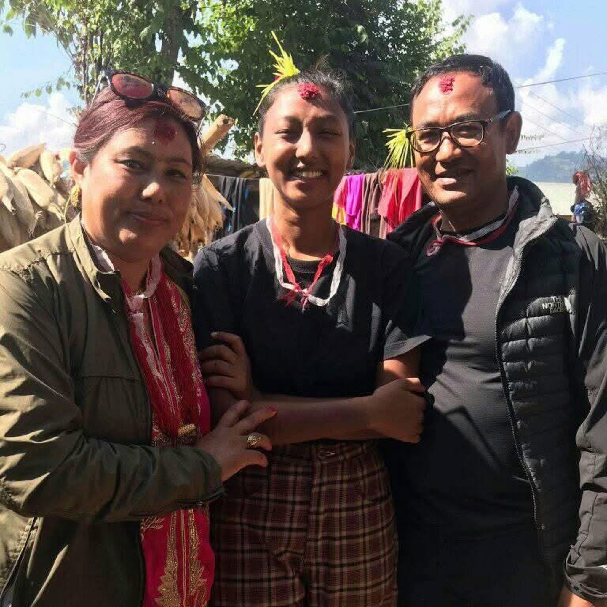 Three people pose for the camera, smiling.